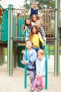 Young Children Sitting On Climbing Frame In Playground