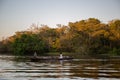 Young children sitting in a wooden rowing boat on the Amazon River at sunset in Brazil, South America Royalty Free Stock Photo