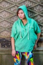 Young Chinese American woman standing against wall in New York City, looking forward, thinking Royalty Free Stock Photo