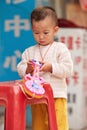 Young Chinese boy playing with his plastic toy, Guangzhou, China