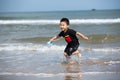 A young Chinese boy playing and running on the beach Royalty Free Stock Photo