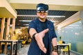 Young Chinese businessman working in office with virtual reality glasses on head. Man using VR headset for handshaking Royalty Free Stock Photo