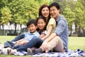 Young Chinese Family Relaxing In Park Together Royalty Free Stock Photo