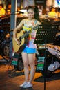 Young Chinese girl playing acoustic guitar and singing in the street in Beijing Royalty Free Stock Photo