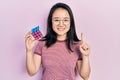 Young chinese girl playing colorful puzzle cube intelligence game smiling with an idea or question pointing finger with happy Royalty Free Stock Photo