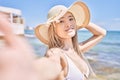 Young chinese girl wearing bikini making selfie by the camera at the beach Royalty Free Stock Photo