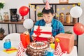 Young chinese man celebrating birthday unboxing gift at home Royalty Free Stock Photo