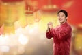 Young chinese man in cheongsam suit standing with hanging lanterns Royalty Free Stock Photo