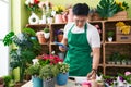 Young chinese man florist using touchpad writing on notebook at flower shop Royalty Free Stock Photo