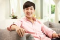 Young Chinese Man Relaxing On Sofa At Home Royalty Free Stock Photo
