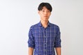 Young chinese man wearing casual blue shirt standing over isolated white background depressed and worry for distress, crying angry Royalty Free Stock Photo