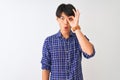 Young chinese man wearing casual blue shirt standing over isolated white background doing ok gesture shocked with surprised face, Royalty Free Stock Photo