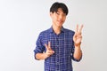 Young chinese man wearing casual blue shirt standing over isolated white background smiling looking to the camera showing fingers Royalty Free Stock Photo