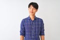 Young chinese man wearing casual blue shirt standing over isolated white background smiling looking to the side and staring away Royalty Free Stock Photo