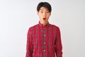Young chinese man wearing casual red shirt standing over isolated white background afraid and shocked with surprise expression, Royalty Free Stock Photo