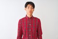 Young chinese man wearing casual red shirt standing over isolated white background depressed and worry for distress, crying angry Royalty Free Stock Photo