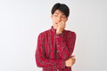 Young chinese man wearing casual red shirt standing over isolated white background looking stressed and nervous with hands on Royalty Free Stock Photo