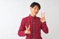 Young chinese man wearing casual red shirt standing over isolated white background smiling looking to the camera showing fingers Royalty Free Stock Photo