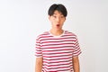Young chinese man wearing casual striped t-shirt standing over isolated white background afraid and shocked with surprise Royalty Free Stock Photo