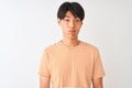 Young chinese man wearing casual striped t-shirt standing over isolated white background depressed and worry for distress, crying Royalty Free Stock Photo