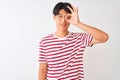 Young chinese man wearing glasses and striped t-shirt standing over isolated white background doing ok gesture with hand smiling, Royalty Free Stock Photo