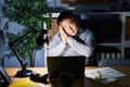 Young chinese man working using computer laptop at night sleeping tired dreaming and posing with hands together while smiling with Royalty Free Stock Photo