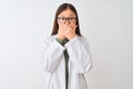 Young chinese scientist woman wearing coat and glasses over isolated white background shocked covering mouth with hands for Royalty Free Stock Photo