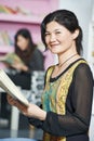 Young chinese student girl with book in library