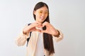 Young chinese student woman wearing glasses and backpack over isolated white background smiling in love showing heart symbol and Royalty Free Stock Photo