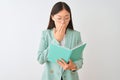 Young chinese student woman wearing glasses reading book over isolated white background cover mouth with hand shocked with shame Royalty Free Stock Photo