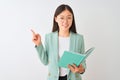 Young chinese student woman wearing glasses reading book over isolated white background very happy pointing with hand and finger Royalty Free Stock Photo