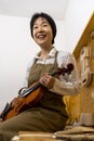 Young Chinese violin maker at work in her workshop Royalty Free Stock Photo