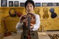 Young Chinese violin maker at work in her workshop Royalty Free Stock Photo