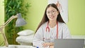 Young chinese woman doctor using laptop wearing glasses at clinic Royalty Free Stock Photo