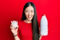 Young chinese woman drinking a glass of fresh milk smiling and laughing hard out loud because funny crazy joke Royalty Free Stock Photo