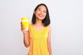 Young chinese woman drinking take away glass of coffee over isolated white background with a happy face standing and smiling with Royalty Free Stock Photo