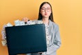 Young chinese woman holding briefcase full of dollars puffing cheeks with funny face Royalty Free Stock Photo