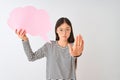 Young chinese woman holding cloud speech bubble over isolated white background with open hand doing stop sign with serious and