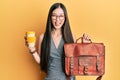 Young chinese woman holding leather bag and drinking a take away coffee smiling and laughing hard out loud because funny crazy