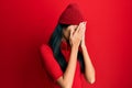 Young chinese woman listening to music using headphones with sad expression covering face with hands while crying Royalty Free Stock Photo