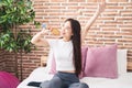 Young chinese woman singing song using brush as a microphone at bedroom Royalty Free Stock Photo