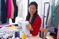 Young chinese woman tailor smiling confident using sewing machine at atelier Royalty Free Stock Photo