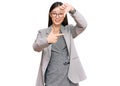 Young chinese woman wearing business clothes smiling making frame with hands and fingers with happy face