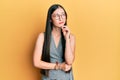 Young chinese woman wearing business dress and glasses thinking concentrated about doubt with finger on chin and looking up