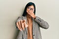 Young chinese woman wearing business style and glasses laughing at you, pointing finger to the camera with hand over mouth, shame Royalty Free Stock Photo