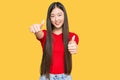 Young chinese woman wearing casual clothes approving doing positive gesture with hand, thumbs up smiling and happy for success Royalty Free Stock Photo