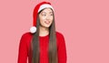 Young chinese woman wearing christmas hat looking away to side with smile on face, natural expression Royalty Free Stock Photo