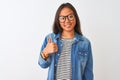 Young chinese woman wearing denim shirt and glasses over isolated white background doing happy thumbs up gesture with hand Royalty Free Stock Photo