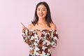 Young chinese woman wearing floral t-shirt standing over isolated pink background smiling and looking at the camera pointing with Royalty Free Stock Photo