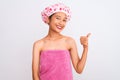 Young chinese woman wearing shower towel and cap bath over isolated white background doing happy thumbs up gesture with hand Royalty Free Stock Photo